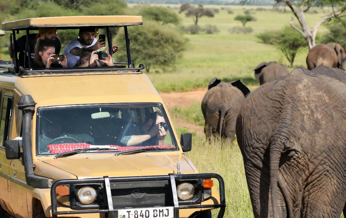 A few tourists on a safari vehicle in Tanzania.