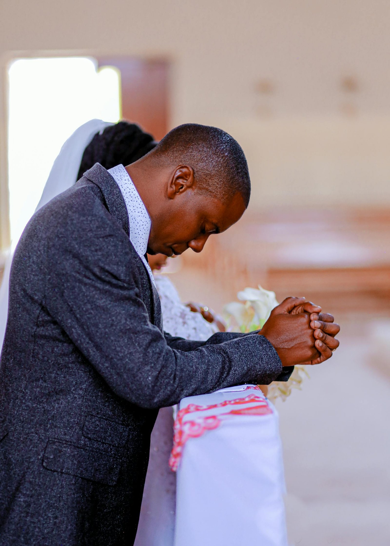 A Tanzanian couple kneeling at an altar.